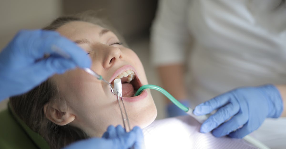 unrecognizable dentists using medical equipment during teeth treatment in modern clinic